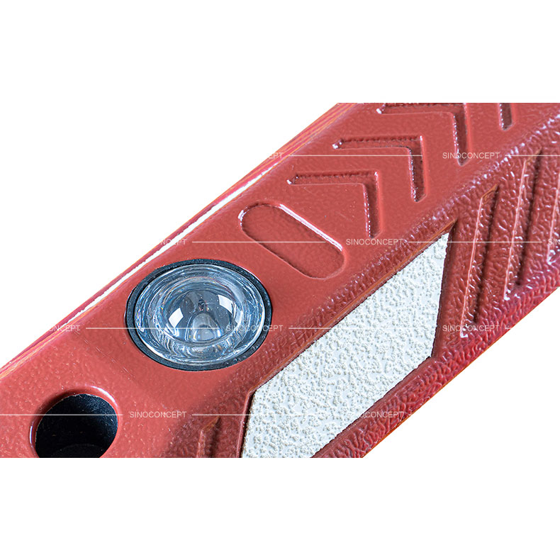 Séparateur de voie en composite plastique-caoutchouc rouge avec des plots routiers en verre et des flèches sur la surface, utilisé pour la sécurité routière.